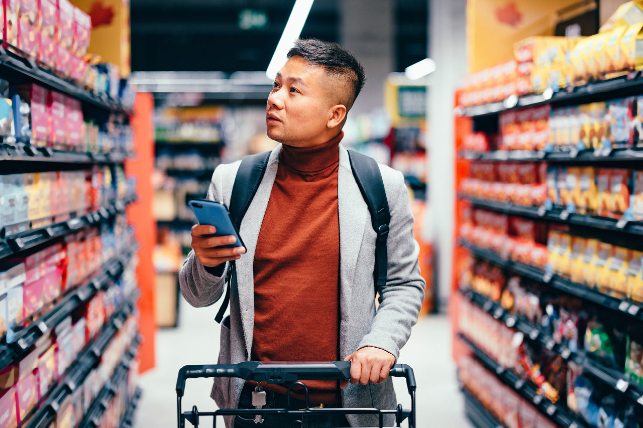 Une personne qui fait ses courses chez Colruyt avec l’app Xtra.